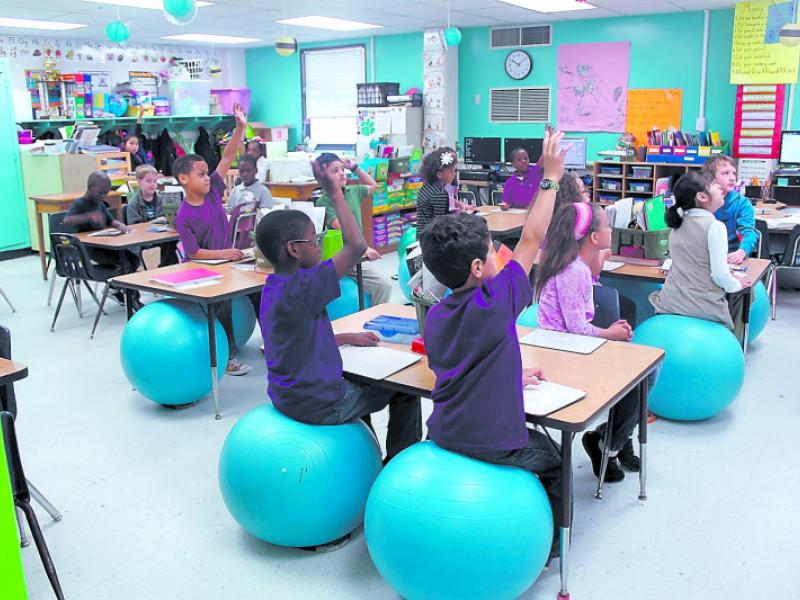 A classroom of attentive students sitting on balance balls